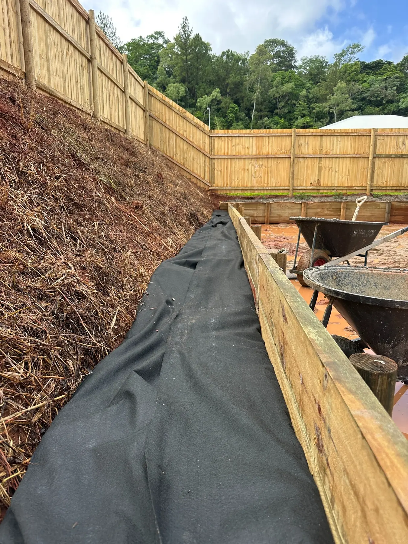 Geofabric and timber retaining wall detail during construction