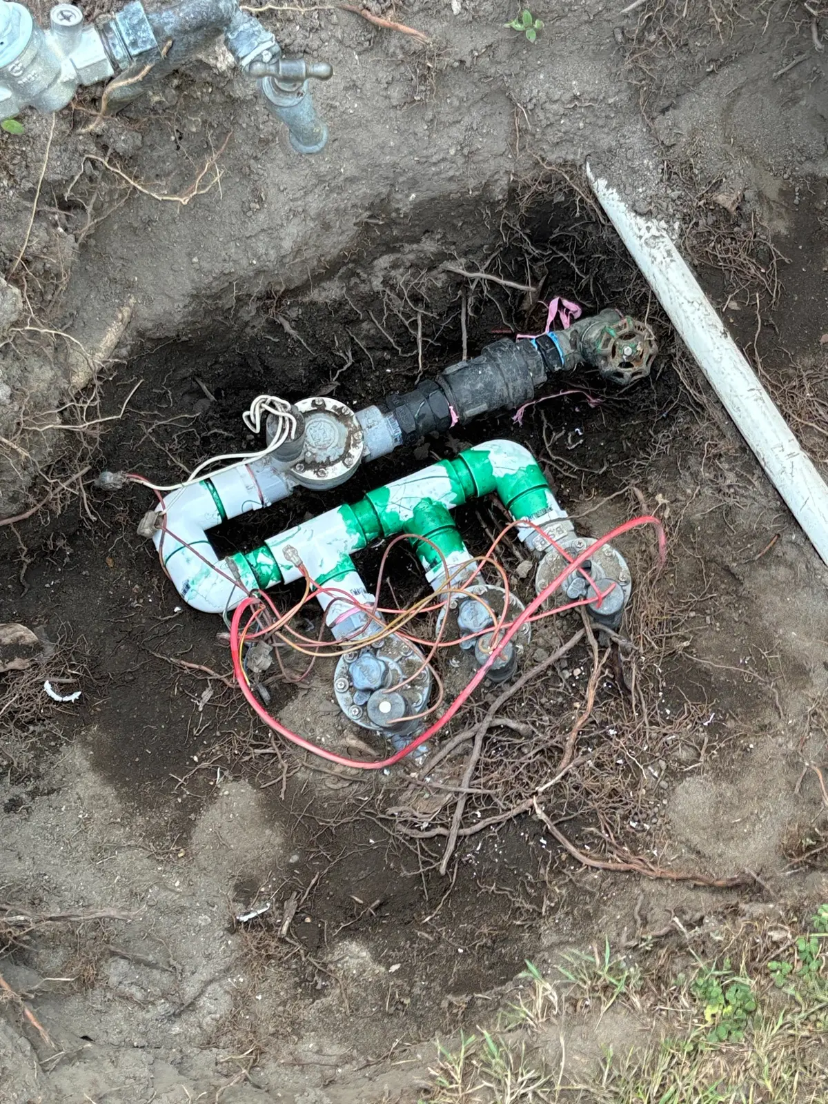 Irrigation valve manifold exposed for PVC pipe and valve repairs